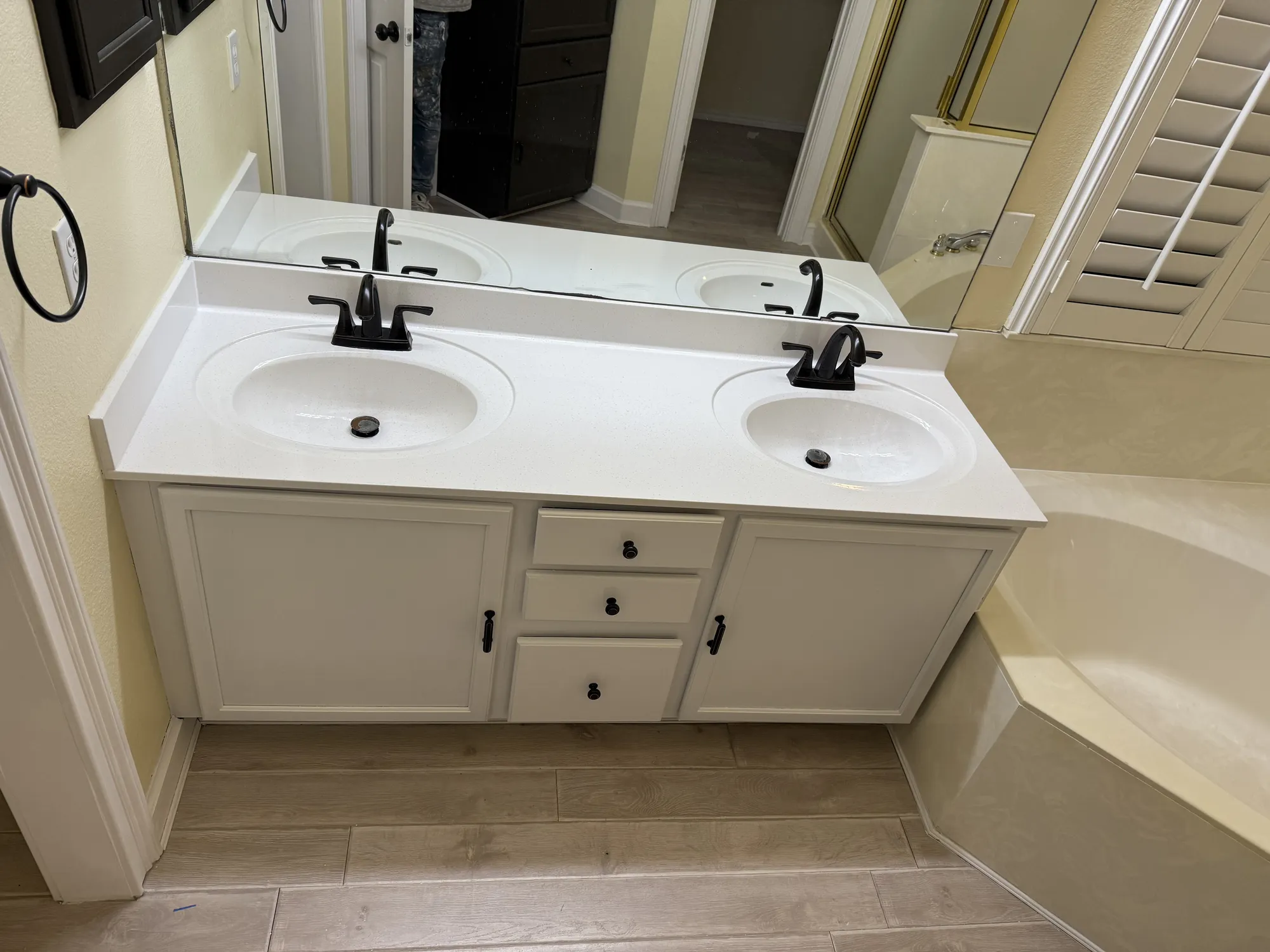 The same vanity with cabinets refinished white and a clean countertop