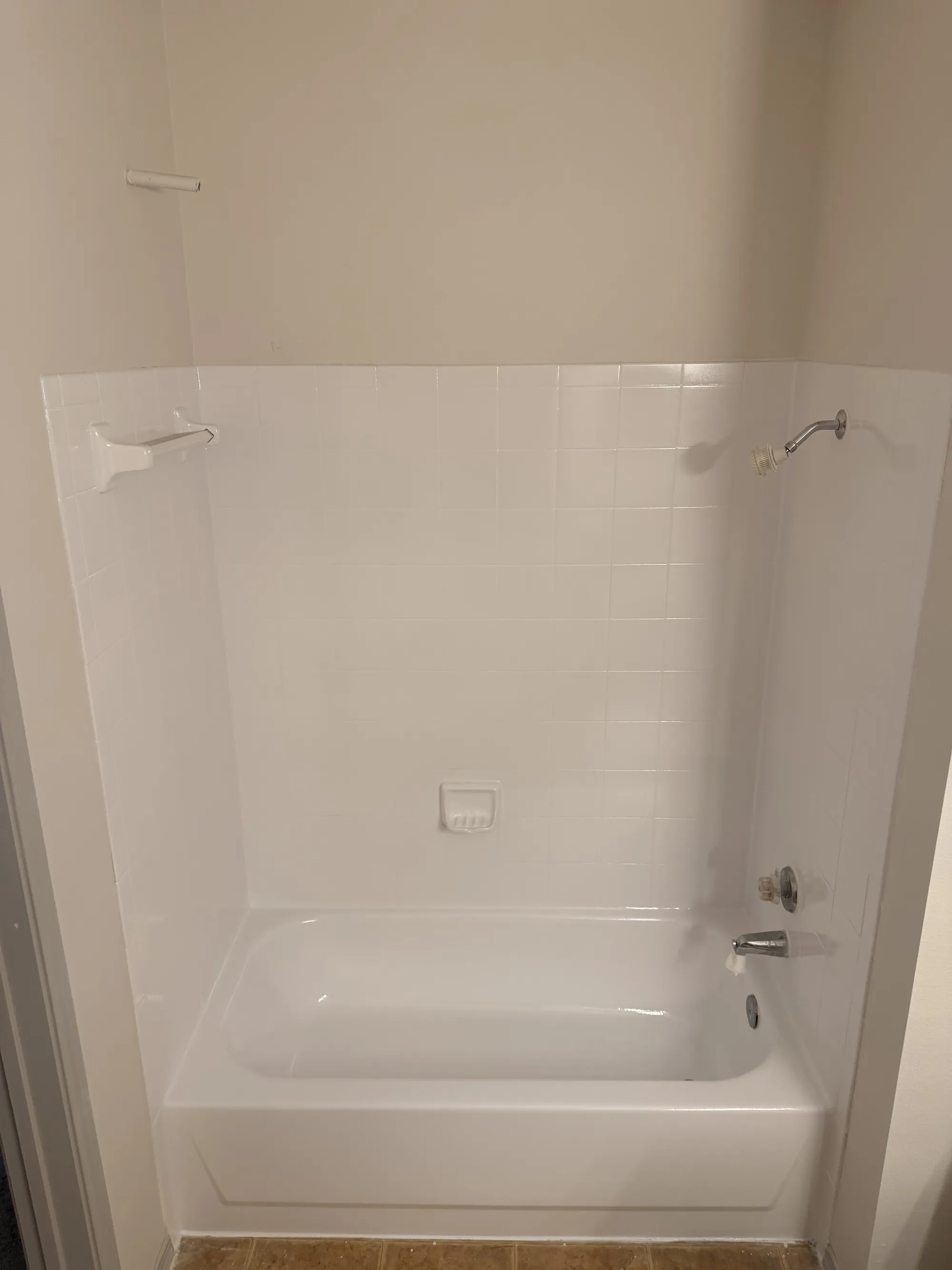 The same wall tile and tub refinished to a uniform glossy white